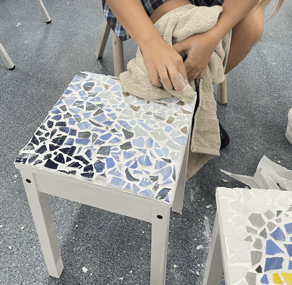 Yr 10 student recycling broken glass and ceramics to mosaic a table